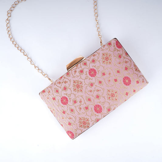 Handcrafted clutch in vibrant Banarasi fabric with intricate motifs, ideal for pairing with sarees, lehengas, and festive suits