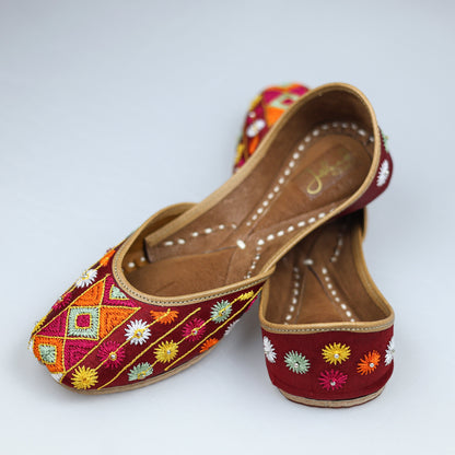 Maroon Phulkari jutti paired with ethnic wear, highlighting vibrant handcrafted design and traditional elegance