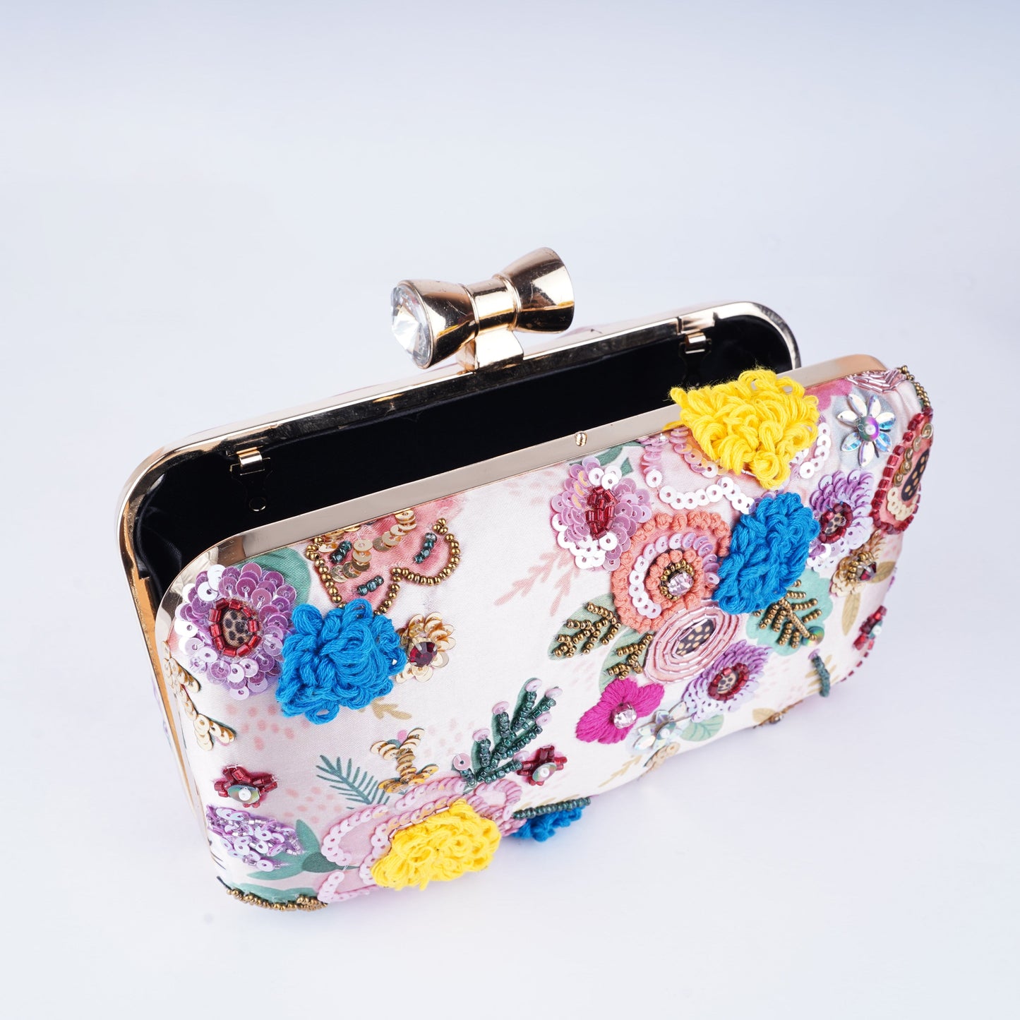 Traditional meets trendy in this clutch featuring fine embroidery on printed textile, perfect for weddings and parties