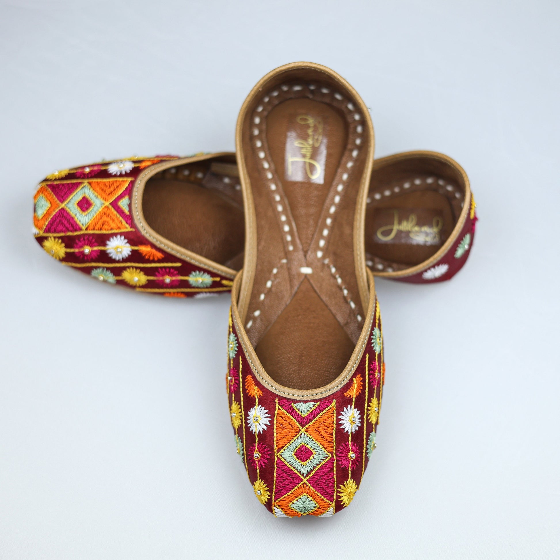 Handcrafted maroon jutti with traditional Phulkari embroidery, inspired by Punjabi culture and festive fashion